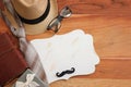 bow tie, fedora hat, glasses, old photo camera and funny moustache over wooden background. top view, flat Royalty Free Stock Photo