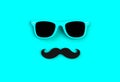 Father`s day concept. Hipster blue sunglasses and funny moustache on blue background