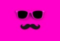 Father`s day concept. Hipster pink sunglasses and funny moustache on pink background