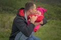 Father`s day. Father hugs and kisses his happy daughter at green park Royalty Free Stock Photo