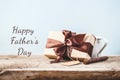 Father`s Day. Gift box with a tag and coffee cup on a wooden background Copy space Text Royalty Free Stock Photo