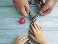 father`s day hands dad and child daughter holding heart tie on blue wooden background Royalty Free Stock Photo