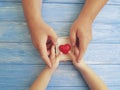 Father`s Day Hands Dad and Child holding Gift Box Heart on a Blue Wooden Background Royalty Free Stock Photo