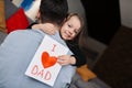 Father's day. Happy family daughter holding a greeting card on holiday and hugging her father Royalty Free Stock Photo