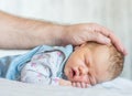 Father`s hand stroking a newborn baby