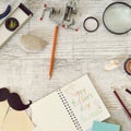 Father`s tools, black paper mustache, magnifying glass, pencils and a greeting inscription in a notebook on a light wooden table