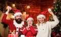 Father Santa claus costume with family celebrating christmas. Lovely daughter with parents wearing Santa hat. Gifts from