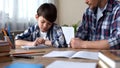 Father scolding son, making him to do homework, boy beginning to write task Royalty Free Stock Photo