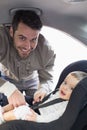 Father securing baby in the car seat Royalty Free Stock Photo