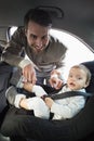 Father securing his baby in the car seat Royalty Free Stock Photo