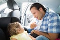 Father securing his baby in the car seat Royalty Free Stock Photo