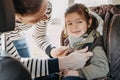 Father securing his toddler daughter buckled into her baby car seat Royalty Free Stock Photo