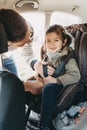 Father securing his toddler daughter buckled into her baby car seat Royalty Free Stock Photo