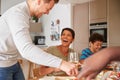 Father Serving As Multi-Generation Mixed Race Family Eat Meal Around Table At Home Together Royalty Free Stock Photo