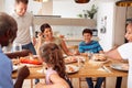 Father Serving As Multi-Generation Mixed Race Family Eat Meal Around Table At Home Together Royalty Free Stock Photo