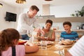 Father Serving As Multi-Generation Mixed Race Family Eat Meal Around Table At Home Together Royalty Free Stock Photo