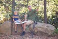 Father showing direction to son in forest