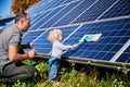 Father showing his little son the solar panels during sunny day.