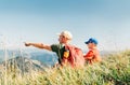 Father showing something interesting to his teenager son sitting on the grass during their mounting hiking walking Royalty Free Stock Photo