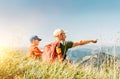 Father showing something interesting to his teenager son sitting on the grass during their mounting hiking walking Royalty Free Stock Photo