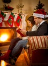 Father sitting with daughter at fireplace and telling story