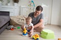 Father sitting on floor with his baby boy and playing with toys Royalty Free Stock Photo