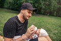 Father sitting outside feeding his baby boy with a bottle Royalty Free Stock Photo