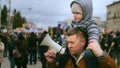 Father with sitting on shoulders kid. Parent with megaphone on political rally.