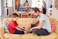 Father Sitting With Son On Sofa Playing Game On Digital Tablet At Home Royalty Free Stock Photo