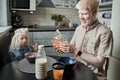 Father sitting at the table with his blonde daughter and preparing eating corn flakes Royalty Free Stock Photo