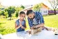 Father with a small daughter outside, making wooden birdhouse.