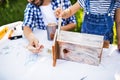 Father with a small daughter outside, making wooden birdhouse. Royalty Free Stock Photo