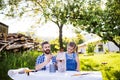 Father with a small daughter outside, painting wooden birdhouse. Royalty Free Stock Photo