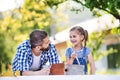 Father with a small daughter outside, painting wooden birdhouse. Royalty Free Stock Photo