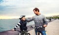 Father and small son with bicycles outdoors standing on beach. Royalty Free Stock Photo