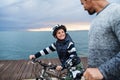 Father and small son with bicycles outdoors standing on beach. Royalty Free Stock Photo