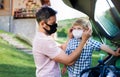 Father with small son going on trip by car, wearing face masks. Royalty Free Stock Photo