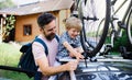 Father with small son putting bicycles on car roof, going on trip concept. Royalty Free Stock Photo