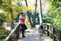 Father with small son on a walk in autumn park, standing on bridge.