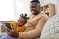 Father with smartphone and baby daughter at home Royalty Free Stock Photo