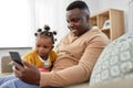 Father with smartphone and baby daughter at home Royalty Free Stock Photo