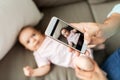 Father with smartphone taking picture baby at home Royalty Free Stock Photo