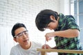 Father and son assemble ready-made furniture. Young carpenter teaching his son