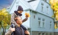 Father and son with autumn maple leaves over house Royalty Free Stock Photo