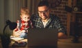 Father and son baby work at home at computer in dark Royalty Free Stock Photo