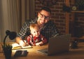 Father and son baby work at home at computer in dark Royalty Free Stock Photo