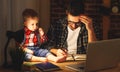 Father and son baby work at home at computer in dark Royalty Free Stock Photo