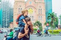 Father and son in the background Notre dame de Saigon Cathedral, build in 1883 in Ho Chi Minh city, Vietnam