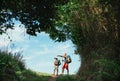 Father and son backpackers hiking by the forest pathway, taking a short rest break. Happy parents travelling with kids concept