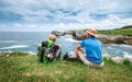 Father and son backpackers rest on the rocky sea side Royalty Free Stock Photo